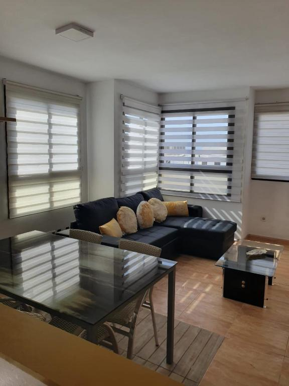 Salón luminoso del apartamento 414 con amplios ventanales y sofá